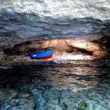 La caverna, illuminata unicamente dall�entrata e da un foro sulla parete superiore protetto da una grata in ferro, � dominata al centro da una piccola barchetta: un gozzo colorato di rosso e blu �attraccato� alla parete attraverso una lunga catena